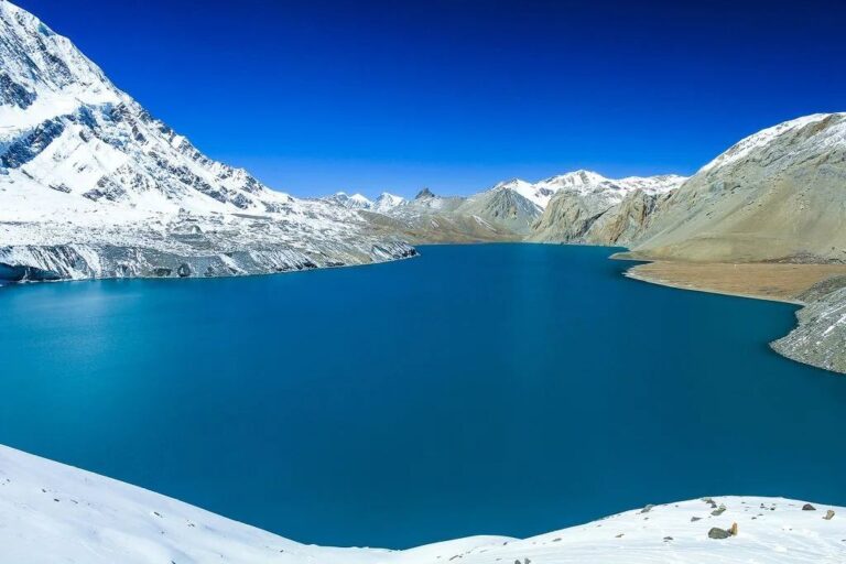 Tilicho Lake Surrounded by Barren landscape and Snow Peaks